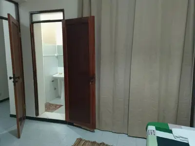 a bathroom with a toilet and a sliding glass door at Essencia Sterra in Praia