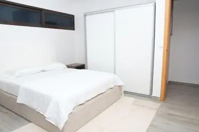 a white bedroom with a bed and a window at Comfort and Peace in Santa Maria