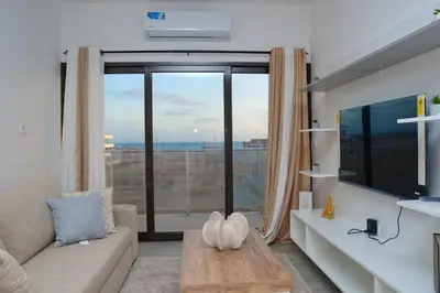 a living room with a couch and a large window at Comfort and Peace in Santa Maria