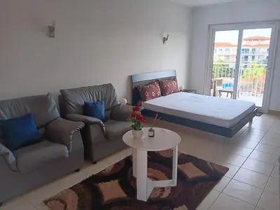 a living room with a bed and a couch and a table at Vila Verde House in Santa Maria