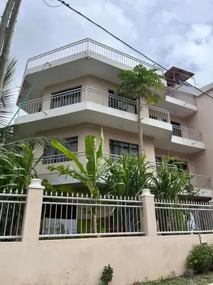 a building with a fence and trees in front of it at Very nice 5 bedroom apartment in Tarrafal in Tarrafal