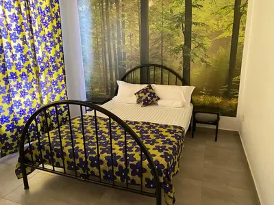 a bedroom with a bed and a large window at une chambre dépaysante in Tarrafal