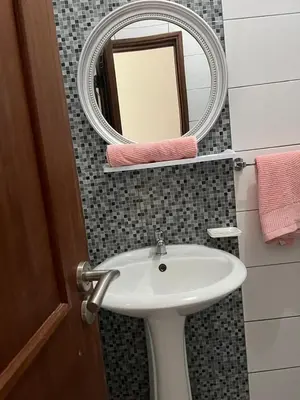 a bathroom with a sink and a mirror at une chambre dépaysante in Tarrafal