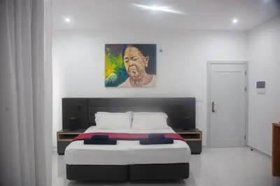 a bedroom with a bed with a painting on the wall at Apart'hotel Assomada in Assomada