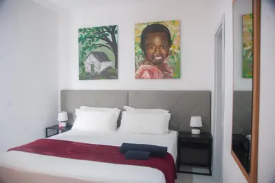 a bedroom with a bed with two pictures on the wall at Apart'hotel Assomada in Assomada