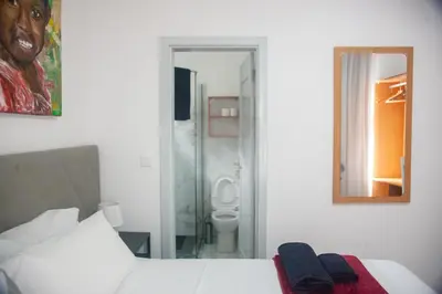 a bedroom with a bed and a bathroom with a toilet at Apart'hotel Assomada in Assomada