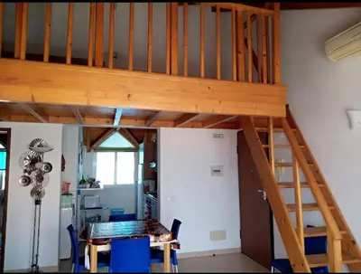 a loft bed in a room with a table at Soleil A5 - Lovely and central apartment in Santa Maria