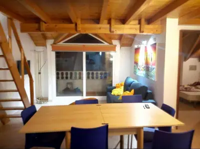 a dining room with a table and blue chairs at Soleil A5 - Lovely and central apartment in Santa Maria