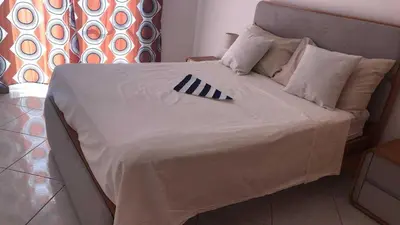 a bed with a black and white blanket on it at Condominio atlantico ll in Praia