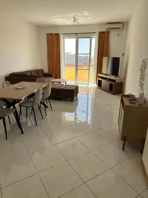 a living room with a table and a couch at Condominio atlantico ll in Praia