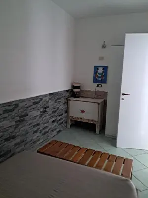 a room with a table and a white refrigerator at Cà Giasone in Santa Maria