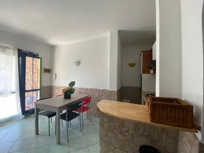 a kitchen and living room with a table and chairs at Cà Giasone in Santa Maria