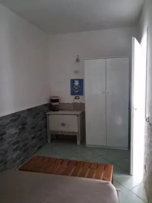 a bedroom with a bed and a table and a cabinet at Cà Giasone in Santa Maria