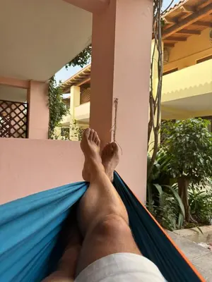 a man laying in a hammock at Porto Antigo, o Paraíso na ilha do Sal, no centro de Sta Maria in Santa Maria