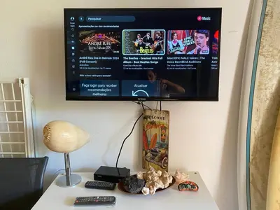 a tv hanging on a wall above a table with a table at Porto Antigo, o Paraíso na ilha do Sal, no centro de Sta Maria in Santa Maria