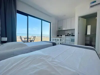 two beds in a room with a view of the beach at Studio Medsal in Santa Maria