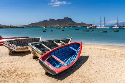 three boats sitting on a beach near the water at Nusa Apartments Monte Cara in Mindelo