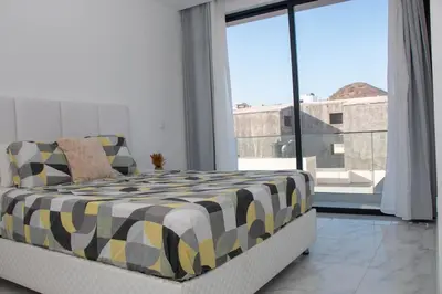 a bedroom with a bed and a large window at Fresh One Apartment in Praia