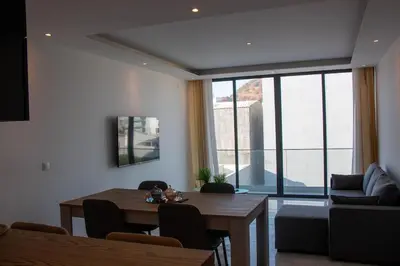 a living room with a table and a couch at Fresh One Apartment in Praia