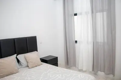 a bedroom with a bed with a black headboard and a window at Fresh One Apartment in Praia
