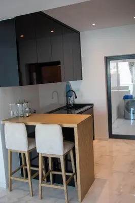a kitchen with a wooden table and two chairs at Fresh One Too Apartment in Praia