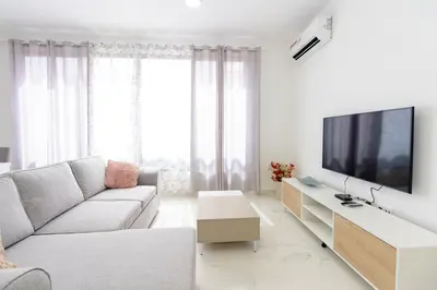 a living room with a couch and a flat screen tv at New building - 1 min away from the main road in Santa Maria