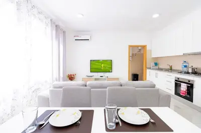 a white living room with a couch and a table at New building - 1 min away from the main road in Santa Maria