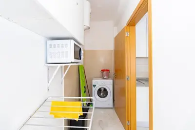 a small kitchen with a washing machine and a microwave at New building - 1 min away from the main road in Santa Maria
