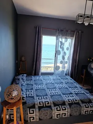 a bedroom with a bed and a window with the ocean at B&B Casa Boho