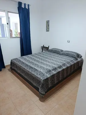 a large bed in a bedroom with blue curtains at B&B Casa Boho