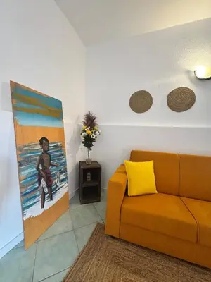 a living room with a couch and a painting on the wall at Holiday Properties Djadsal Pirata - Wi-fi in Santa Maria