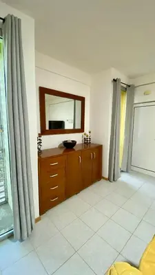 a bathroom with a mirror and a dresser in a room at Airport Residence - Vila Acácia I in Praia