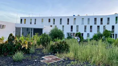 a white building with a garden in front of it at Airport Residence - Vila Acácia I in Praia