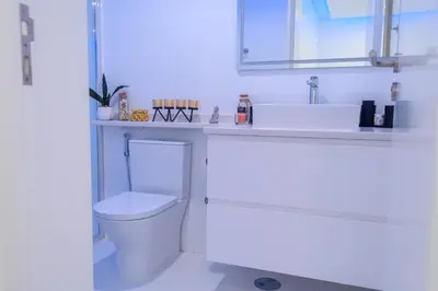 a white bathroom with a toilet and a sink at Yes Rooftop, Private Pool & Sea View, Cidadela in Praia
