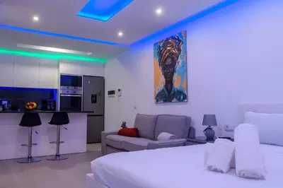 a bedroom with a bed and a couch and a kitchen at Yes Rooftop, Private Pool & Sea View, Cidadela in Praia