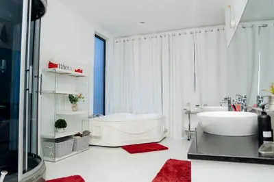 a white bathroom with a tub and a sink at Kretxeu Luxury Villa in Praia