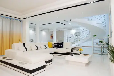 a white living room with a white couch and a staircase at Kretxeu Luxury Villa in Praia