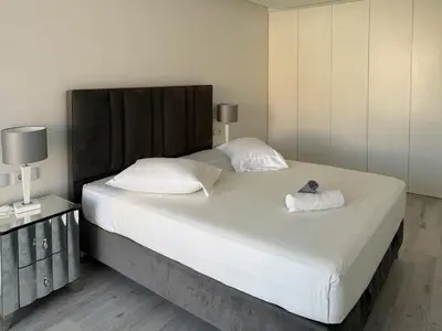 a bedroom with a large bed with two pillows at 2-bdr bright apt central street cidadela - LCGR in Praia