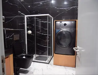 a bathroom with a washing machine and a toilet at Top-Level Pool in Praia