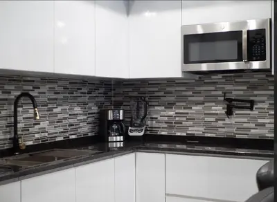 a kitchen with white cabinets and a microwave at Top-Level Pool in Praia