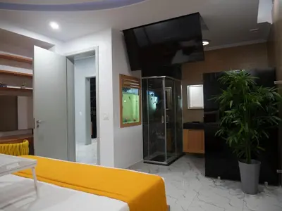 a living room with a yellow couch and a flat screen tv at Top-Level Pool in Praia