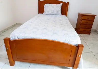 a bed in a bedroom with a wooden bed frame at Residencial Mendes in Tarrafal