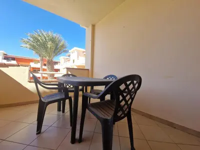 a black table and two chairs on a balcony at T2 Djadsal Bloco Laranja Perto da Praia e Centro in Santa Maria