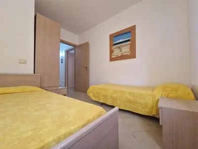 a hotel room with two beds with yellow sheets at T2 Djadsal Bloco Laranja Perto da Praia e Centro in Santa Maria