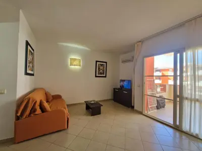 a living room with a couch and a sliding glass door at T2 Djadsal Bloco Laranja Perto da Praia e Centro in Santa Maria