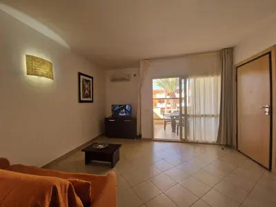 a living room with a couch and a tv and a table at T2 Djadsal Bloco Laranja Perto da Praia e Centro in Santa Maria