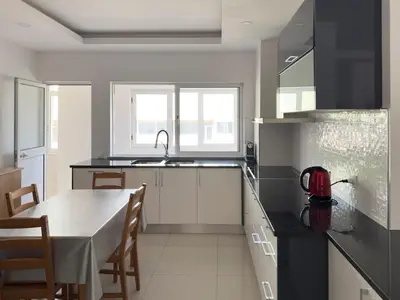 a kitchen with a table and a dining room at Spacious 3-bdr apt seafront, exterior pool - LCGR in Praia