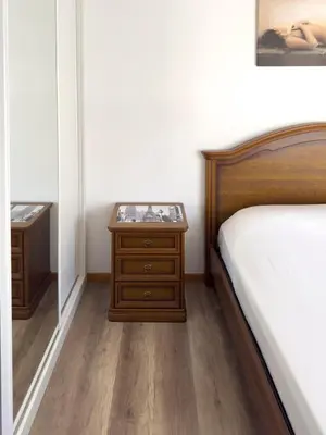 a bedroom with a bed and a wooden nightstand at Spacious 3-bdr apt seafront, exterior pool - LCGR in Praia