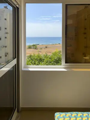 a window in a room with a view of the ocean at Spacious 3-bdr apt seafront, exterior pool - LCGR in Praia