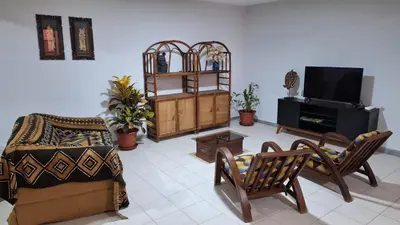 a living room with a couch and a tv at Kaza Manata in Praia